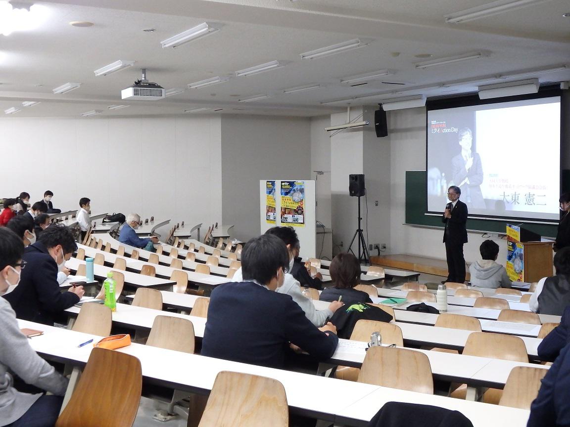 会場の様子と挨拶する大東教授